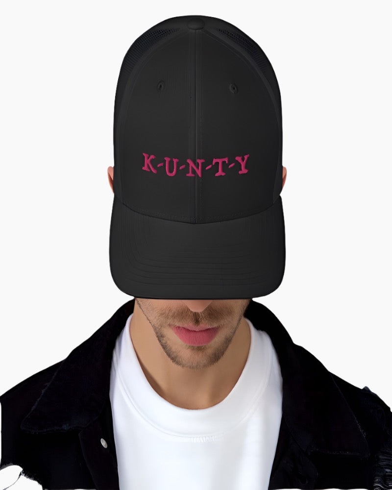 Black trucker hat with K-U-N-T-Y in a bold pink text design, complete with a breathable mesh back, and an adjustable snap closure.