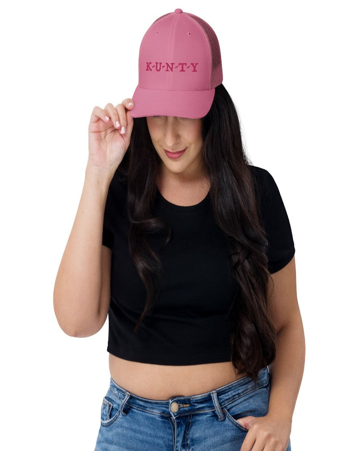 Pink trucker hat with K-U-N-T-Y in a bold pink text design, complete with a breathable mesh back, and an adjustable snap closure.