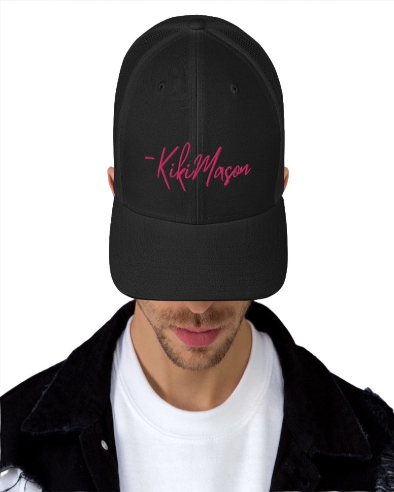 Black trucker hat with Kiki Mason in a bold pink text design, complete with a breathable mesh back, and an adjustable snap closure.