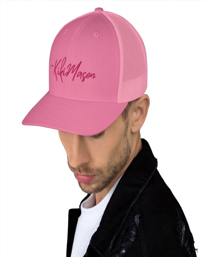 Pink trucker hat with Kiki Mason in a bold pink text design, complete with a breathable mesh back, and an adjustable snap closure.