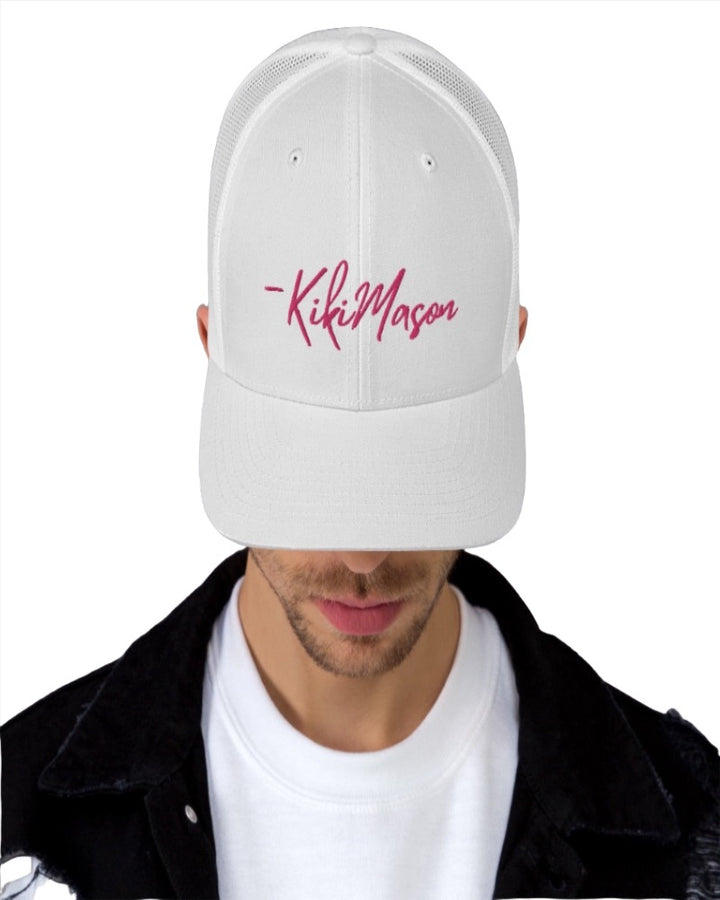 white trucker hat with Kiki Mason in a bold pink text design, complete with a breathable mesh back, and an adjustable snap closure.