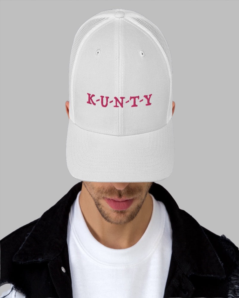 White trucker hat with K-U-N-T-Y in a bold pink text design, complete with a breathable mesh back, and an adjustable snap closure.