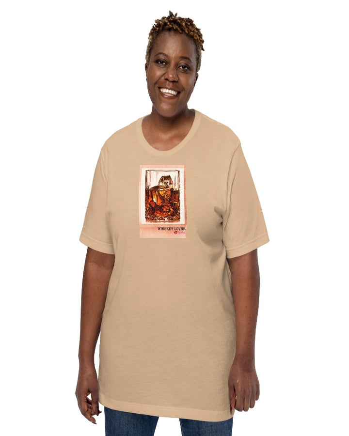 Tan colored T-shirt available in various sizes, featuring a rocks glass of whiskey graphics with a text design "Whiskey Lover" with the logo Kiki Mason Logo