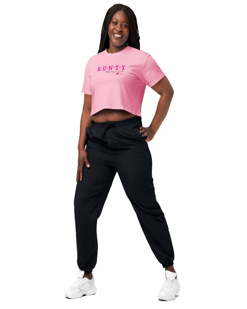 Pink crop top with bold print design, “K-U-N-T-Y” in hot pink raspberry text design, and “that’s the way you like to be” in soft grey text printed on the front. Plain pink back