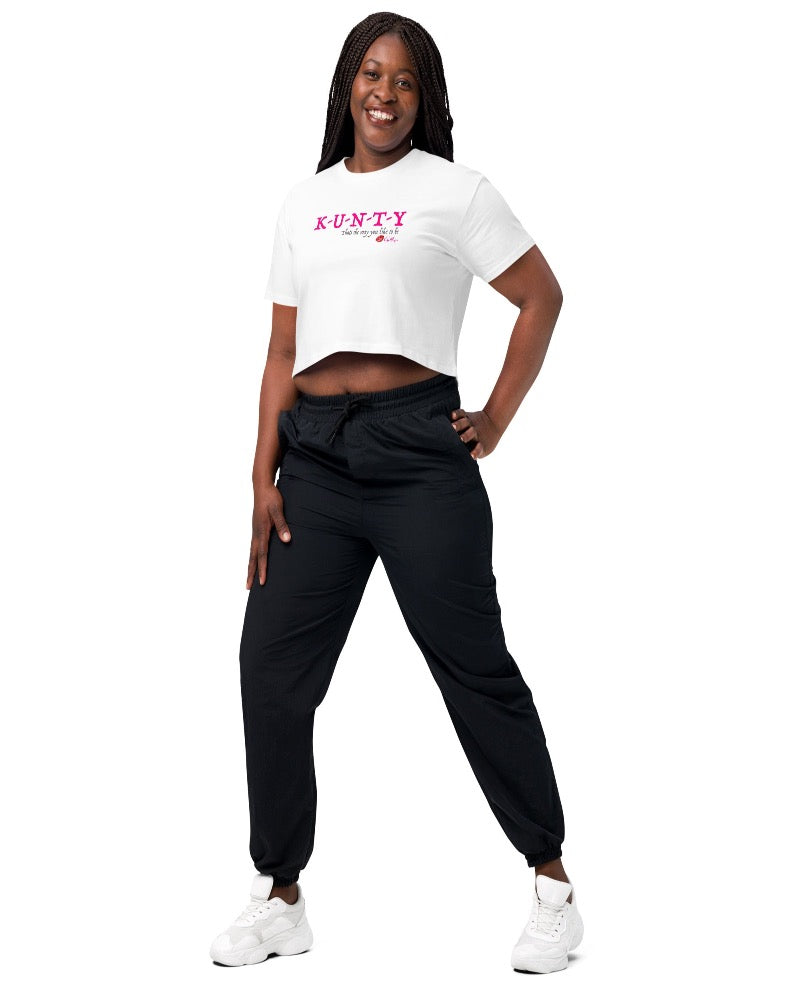 White crop top with bold print design, “K-U-N-T-Y” in hot pink raspberry text design, and “that’s the way you like to be” in soft grey text printed on the front. Plain white back