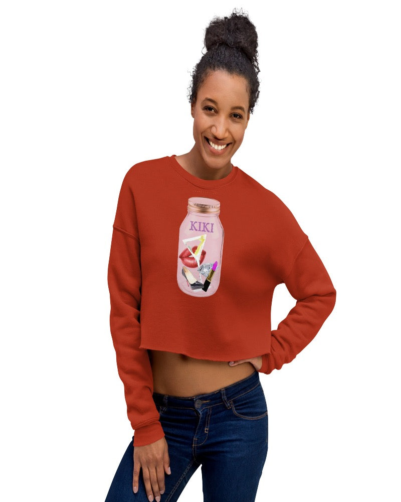 Brick colored cropped sweatshirt with KIKI is written on a mason jar below the lid and filled with martini, lipstick, lip, diamond, high heel